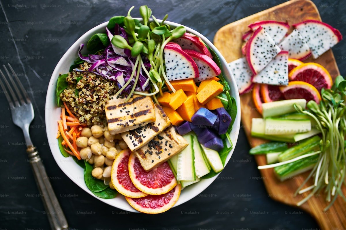 Grilled tofu buddha bowl with chickpeas and fruit showing balanced calorie deficit meal