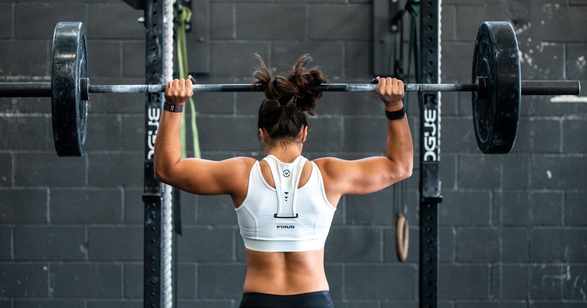 Woman doing weight lifting exercises for strength training and fat loss at the gym