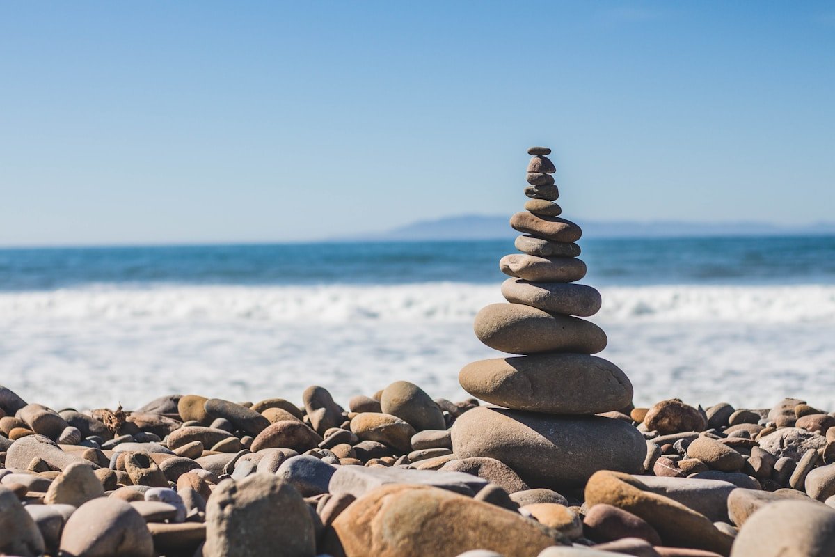 Balanced stones on beach shore symbolizing mindfulness and mental wellness