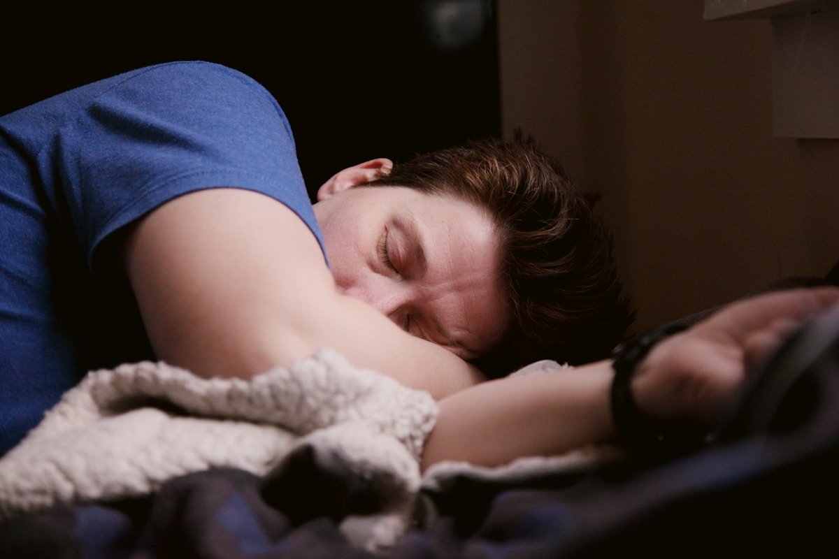 Woman resting in bed showing connection between sleep quality and fat loss