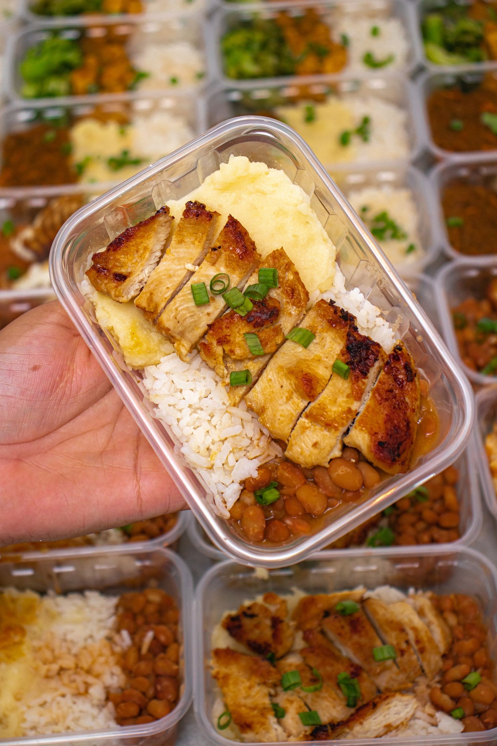 Grilled chicken, rice, and beans portioned in a meal-prep container